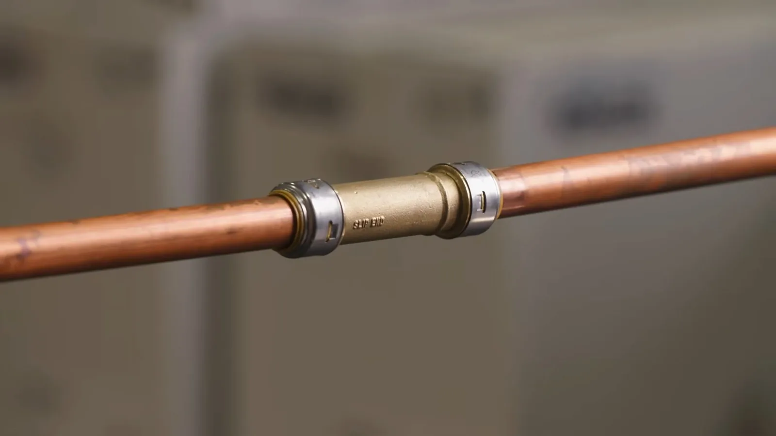 A section of copper pipe joined with a brass push-fit coupling.
